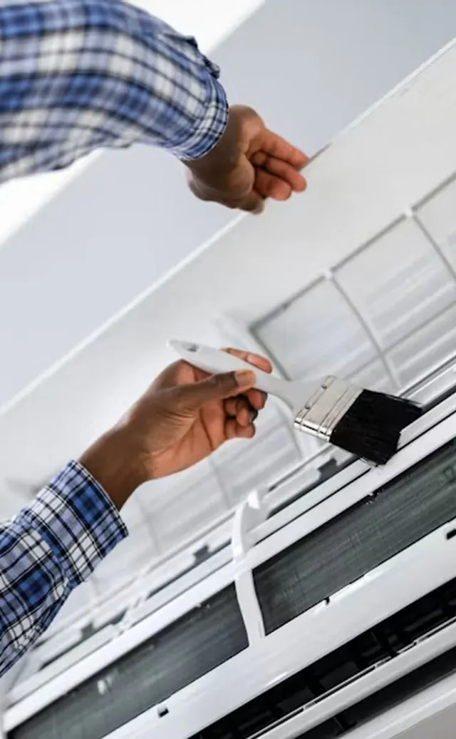 Technician cleaning the coil of a wall-mounted air conditioner