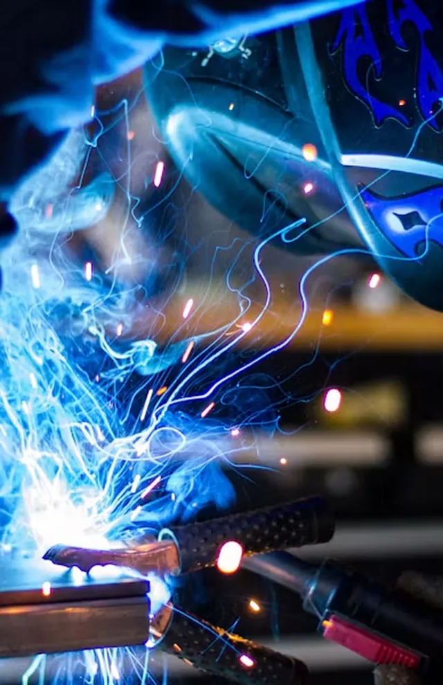Welder at work with sparks flying from the arc